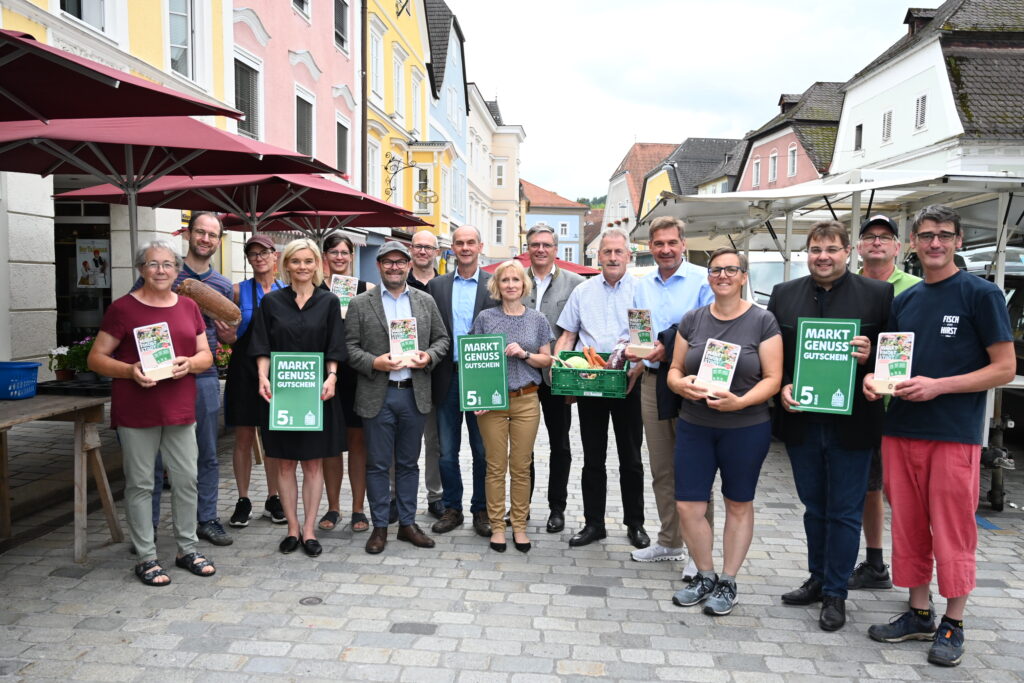 Eine Gruppe von Menschen freut sich über die neuen Waidhofner Marktgutscheine. 