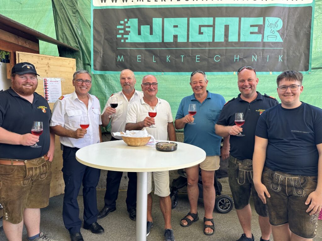 Männer stehen um einen Tisch mit einem Bierglas in der Hand