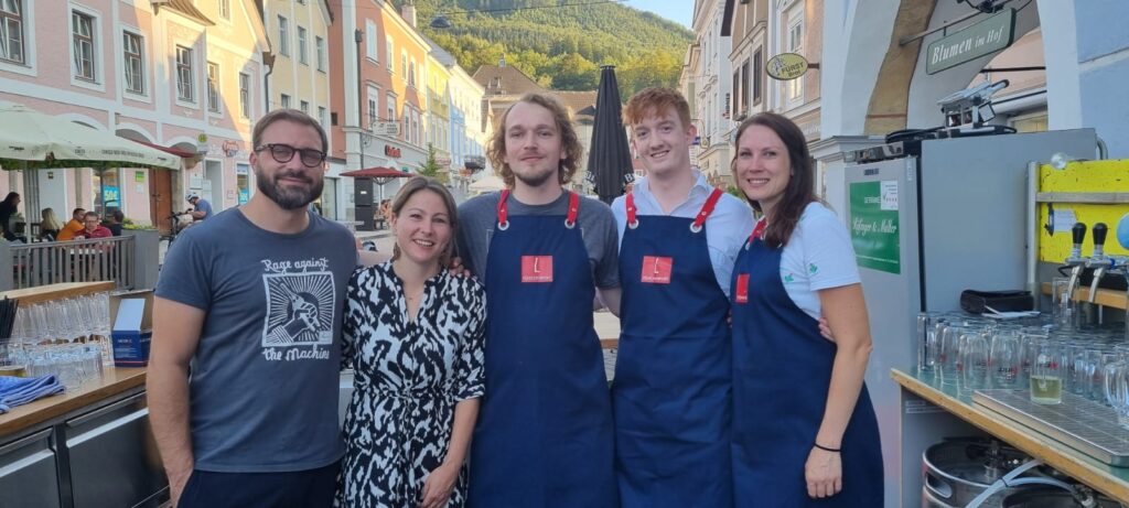 fuenf Personen mit Arbeitsschürze schauen in die Kamera